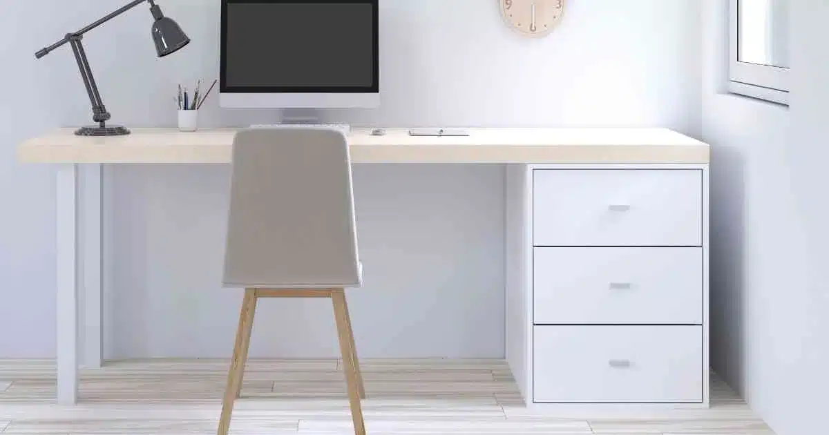 A white desk with a computer and a chair in a room.