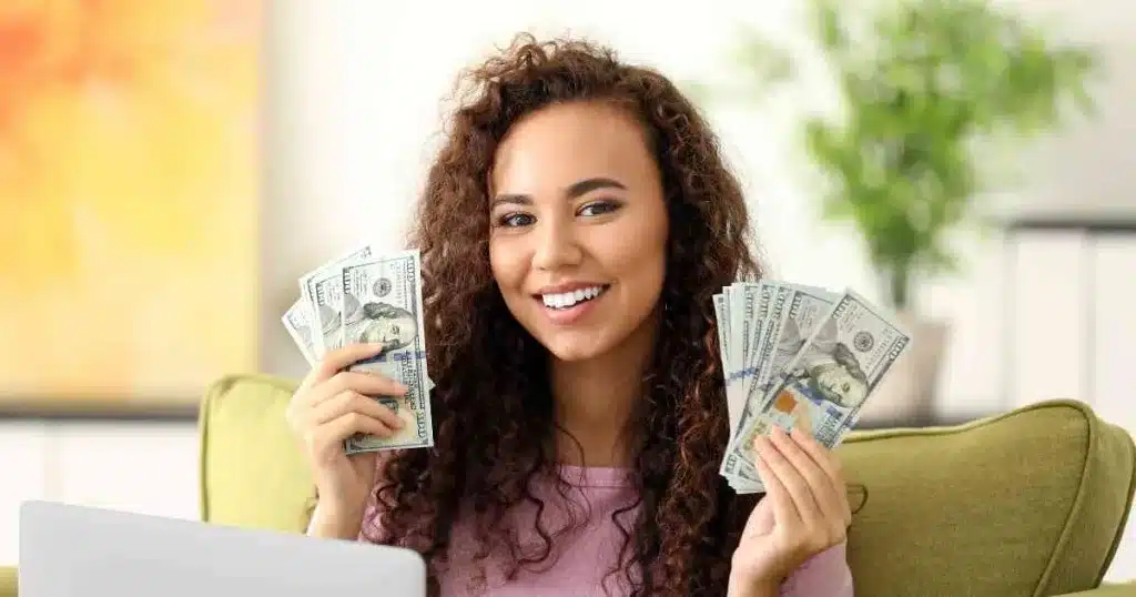A woman sitting on a couch with money in her hands.